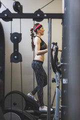 Fototapeta na wymiar Beautiful girl doing workout in the gym