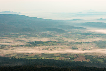 A small village in a valley surrounded by mountains and morning