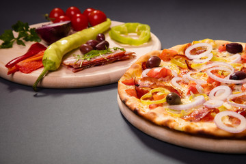 Delicious pizza with ham, vegetables and olives served on wooden