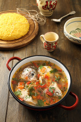 zuppa di pesce in padella di metallo sfondo rustico