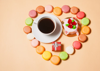 French macaroons, cup of coffee, gift box  and cake 