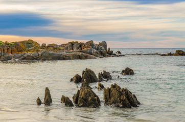 Plakaty  Vibrant orange coast line boulder rocks at the beach