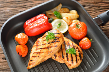 Grilled chicken breasts and vegetables on the grill pan