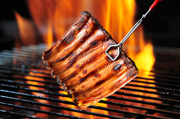 Grilled pork ribs on the flaming grill