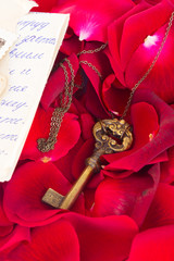 Key with rose petals and old mail