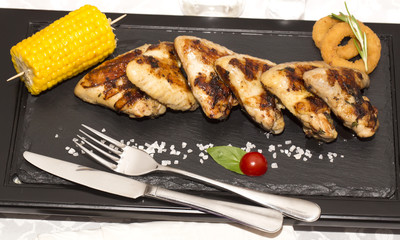 chicken wings are grilled on a wooden platter