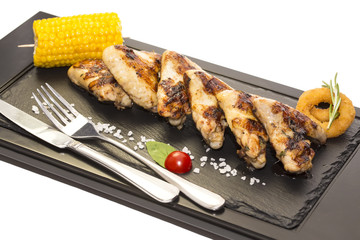 chicken wings are grilled on a wooden platter