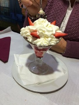 disfrutando un delicioso postre de fresas con nata
