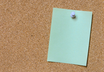 Blank green note pinned on cork board