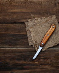Knife and sucking napkin on wooden background