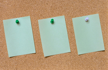 Blank green note pinned on cork board