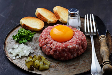 Fresh beef tartar with egg, pickled cucumber and onion.