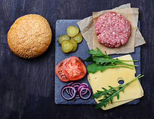 Ingredients for burger: raw cutlet, tomato, cheese, onion