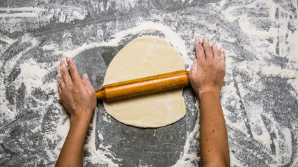 Preparation of the dough . The dough rolling the women's hands.
