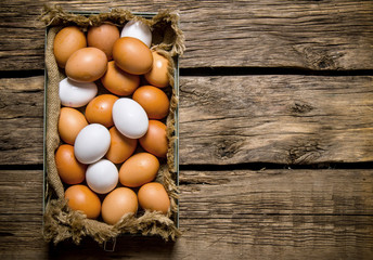 Fresh eggs from the box. On wooden table.