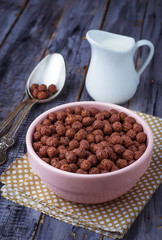 Chocolate cereal balls in bowl and milk