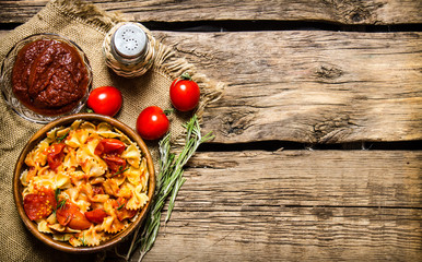 Pasta with tomato sauce, herbs on the fabric.