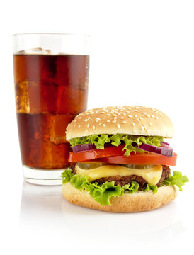 Big cheeseburger with glass of cola isolated on white background