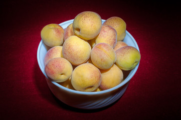 Apricots on dark red background