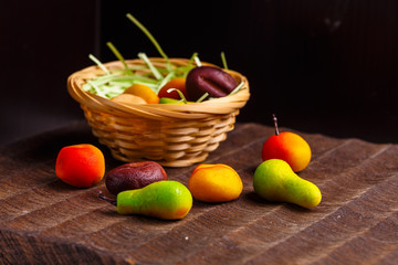 A basket of chocolates from marzipan in the form of fruits is no