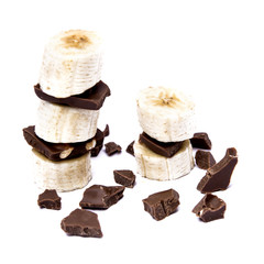 Chocolate tower of banana and cut pieces of chocolate isolated on white