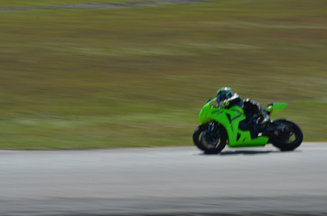 Blurred athletes practicing racing motorcycles on the race track