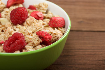 musli with fresh raspberry on wooden background