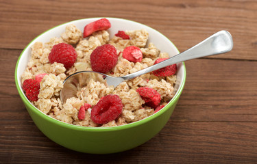musli with fresh raspberry on wooden background