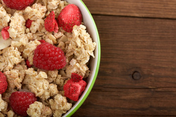 musli with fresh raspberry on wooden background