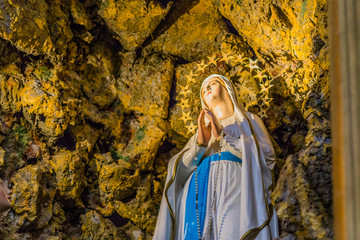 the Blessed Virgin Mary in the grotto at Lourdes - obrazy, fototapety, plakaty