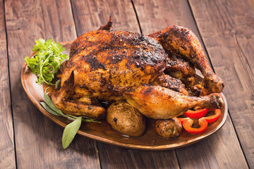 Spicy grilled chicken on wooden plate