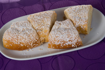 French king cake on a wooden stand. Purple background.