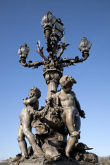 Fototapeta na wymiar Figures on Pont Alexandre III Bridge in Paris, France