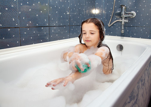 girl washing her hand sitting in the bath