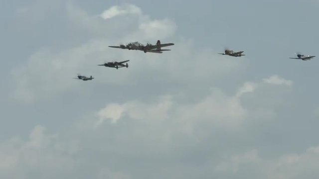 B-17 Flying Fortress leads a formation of four World War II fighter planes, including a P-63 Kingcobra, a P-38 Lightning, and two P-51 Mustangs.  Recorded in 4K, ultra high definition. 