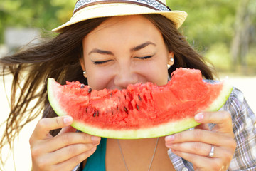Happy young woman eating watermelon on the beach. Youth lifestyl