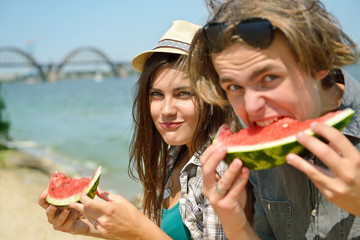 Happy friends eating watermelon on the beach. Youth lifestyle. H