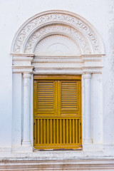 Fototapeta na wymiar Yellow window shutters and white wall