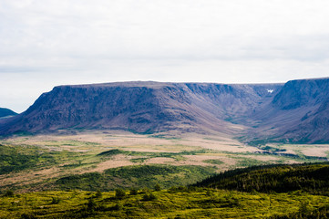 Large mountain plateau and valley under cloudy sky - obrazy, fototapety, plakaty