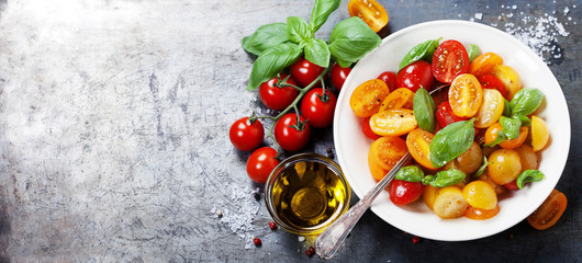 Fresh tomatoes with basil leaves in a bowl