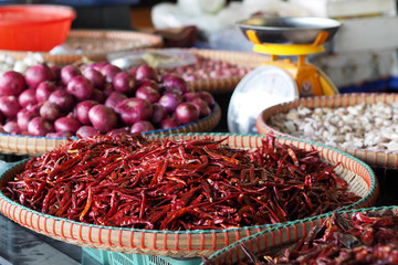 Dried red chili onion garlic in the flat basket stall at market for sell