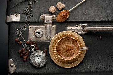 Vintage suitcase, and old clock on a chain and coffee cup