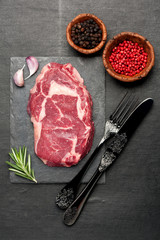 Raw fresh meat Ribeye Steak, seasoning and herbs