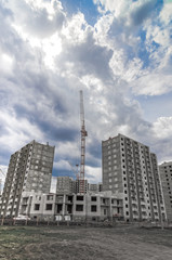 Fototapeta na wymiar New residential building and highrise cranes