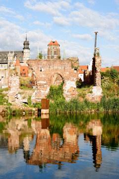 The remains of the walls of the barns Gdańsk destroyed during the Second World War, against the background of the reconstructed Gdansk Old Town