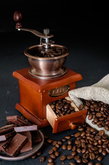 Still life of coffee beans in jute bags with coffee grinder