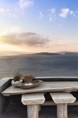 Wooden table and stools at sinrise in Santorini