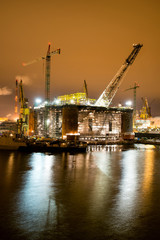 Fototapeta na wymiar Night view of the renovation of an oil rig in the Gdansk Repair Shipyard