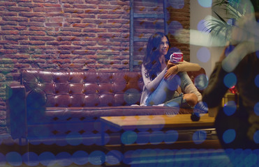 Fototapeta na wymiar Mujer joven tomando café sentada en el sofá