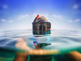 Snorkeling. Selfie shot just below the surface of water. Blue sky.